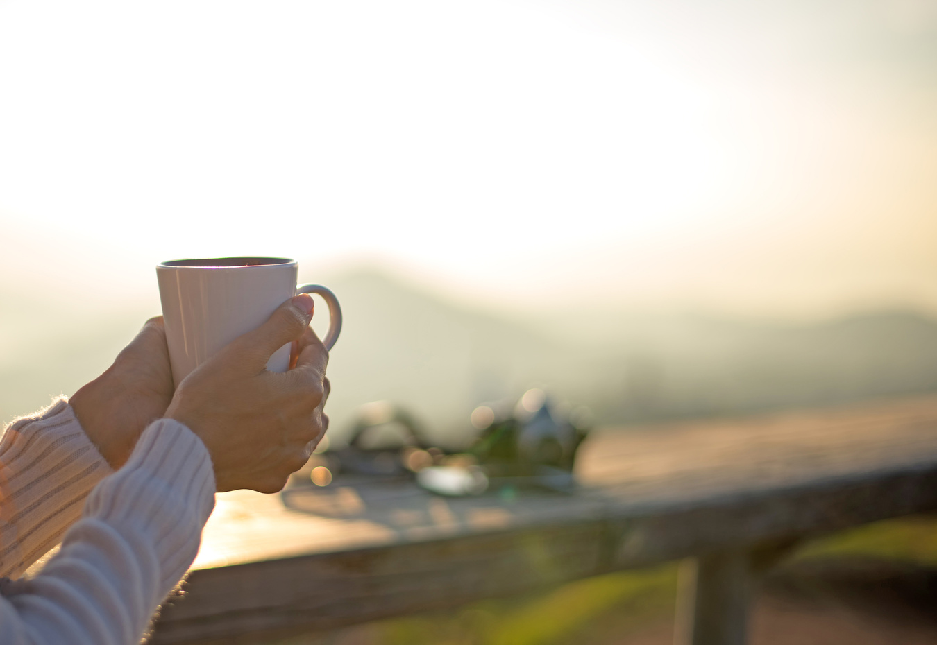 Woman drinking coffee in sun sitting outdoor